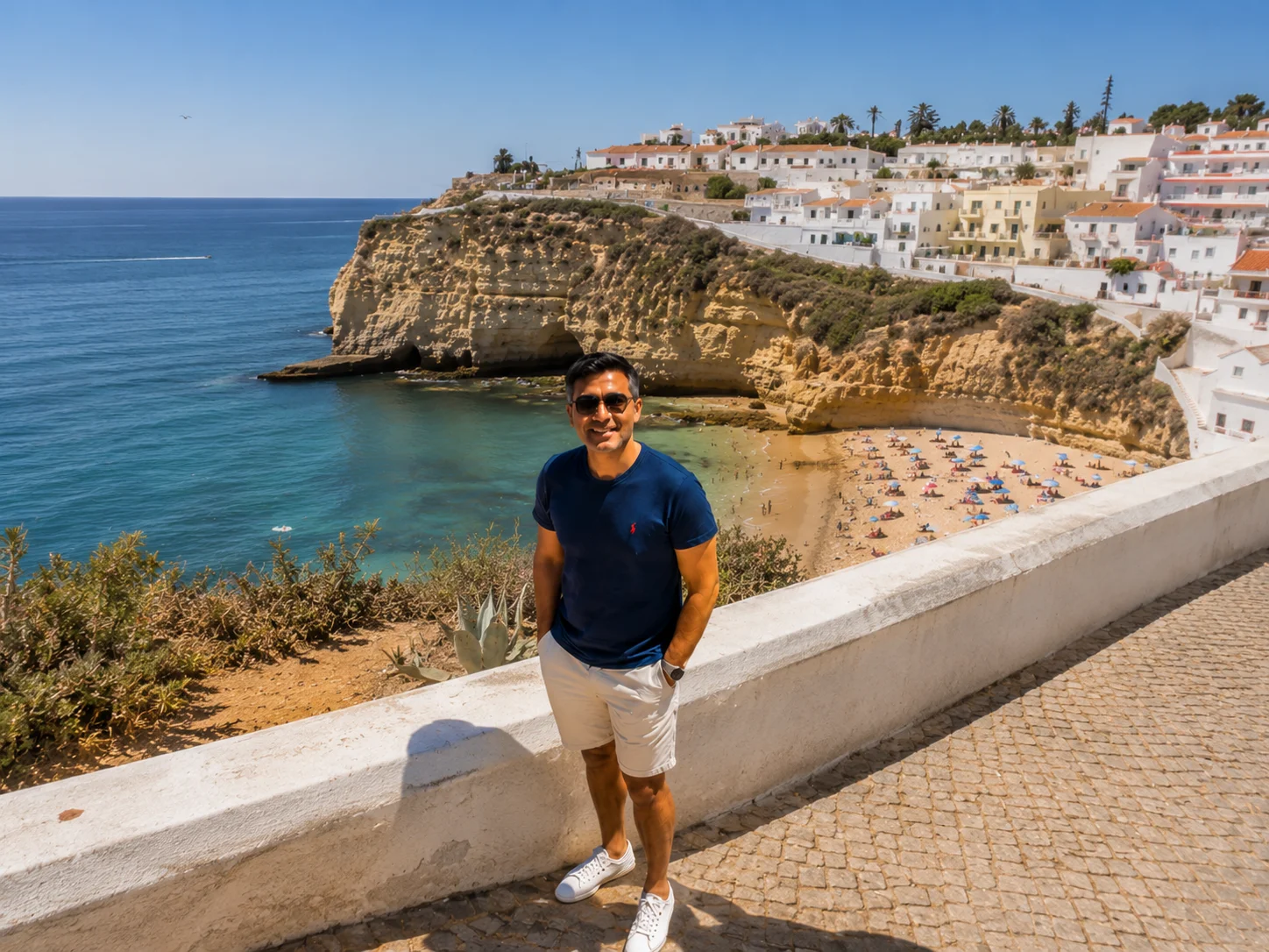 Smiling man on a scenic walkway overlooking Carvoeiro beach and cliffs, Algarve