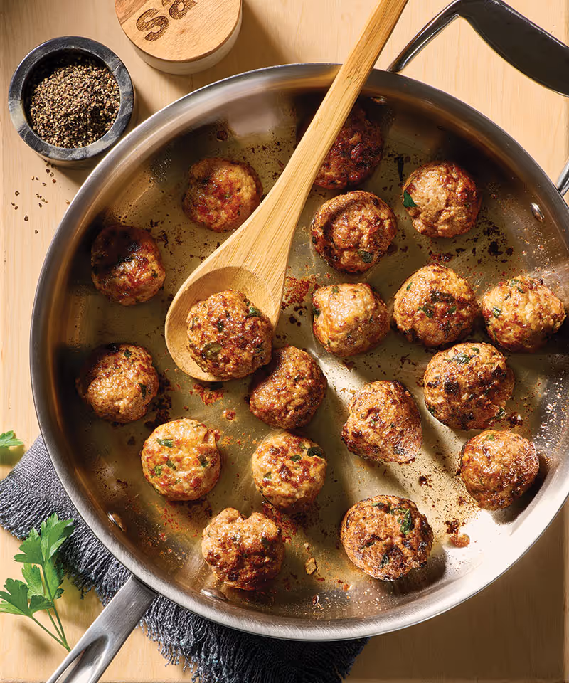 Classic meatballs arranged on a pan, ready for use in a variety of meals.