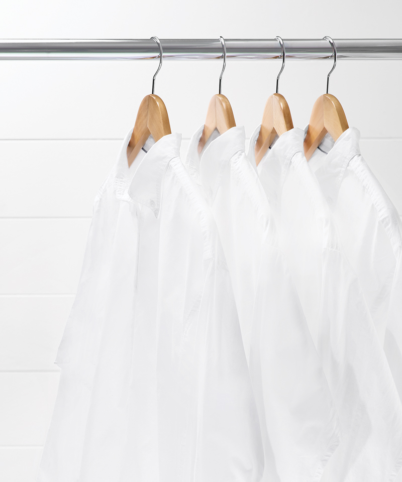 Four hanging white collared shirts.