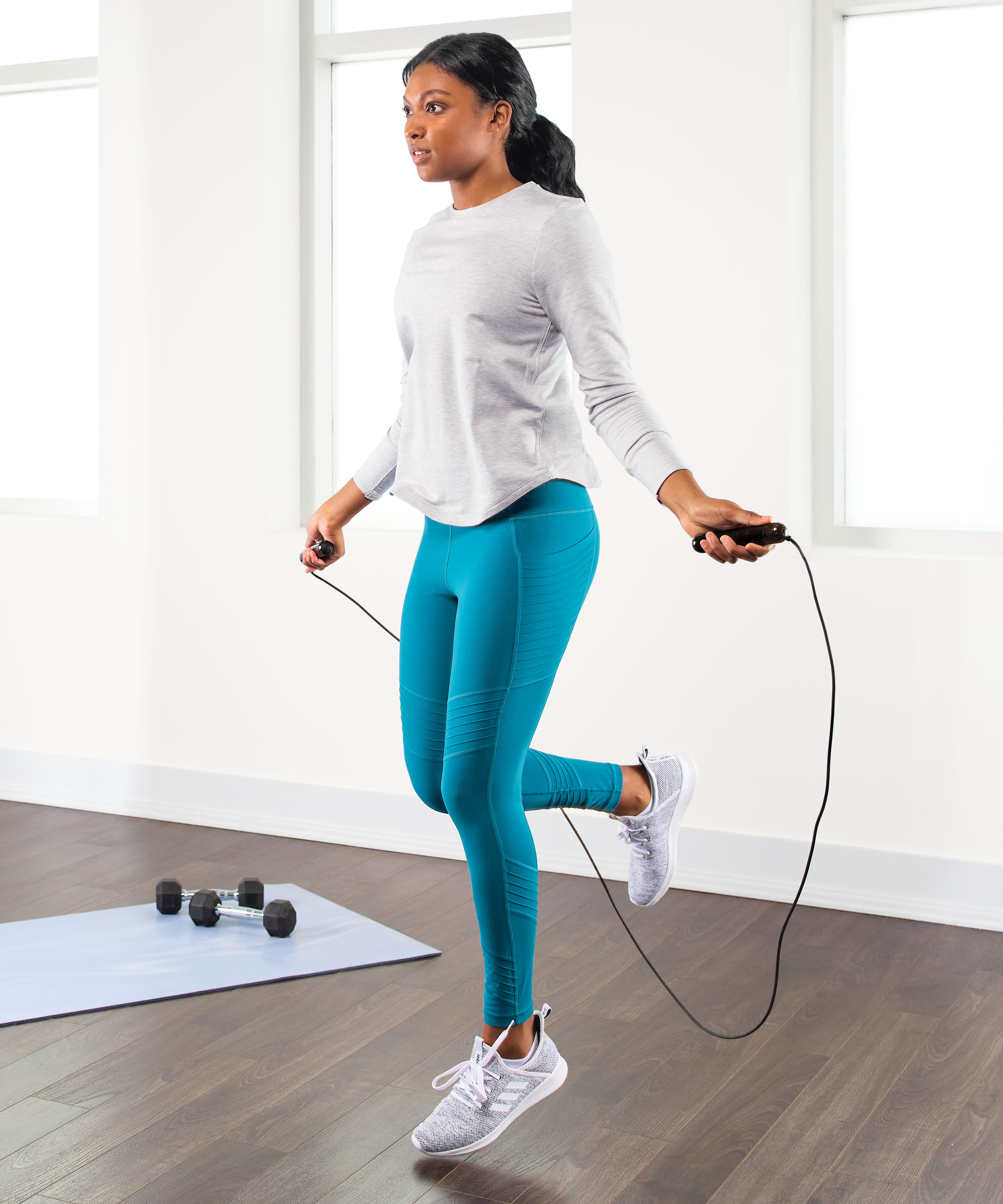 A woman jumping rope in a personal workout studio.