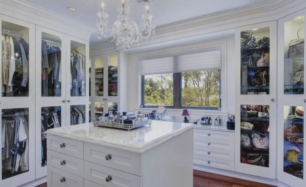 White closet design with white counter for perfumes and hanging chandelier