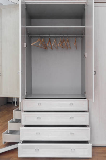 New, fashionable, modern, stylish, light, empty, spacious wooden wardrobe with several drawers in room. Furniture made of natural wood. Concept of interior design. home storage system.