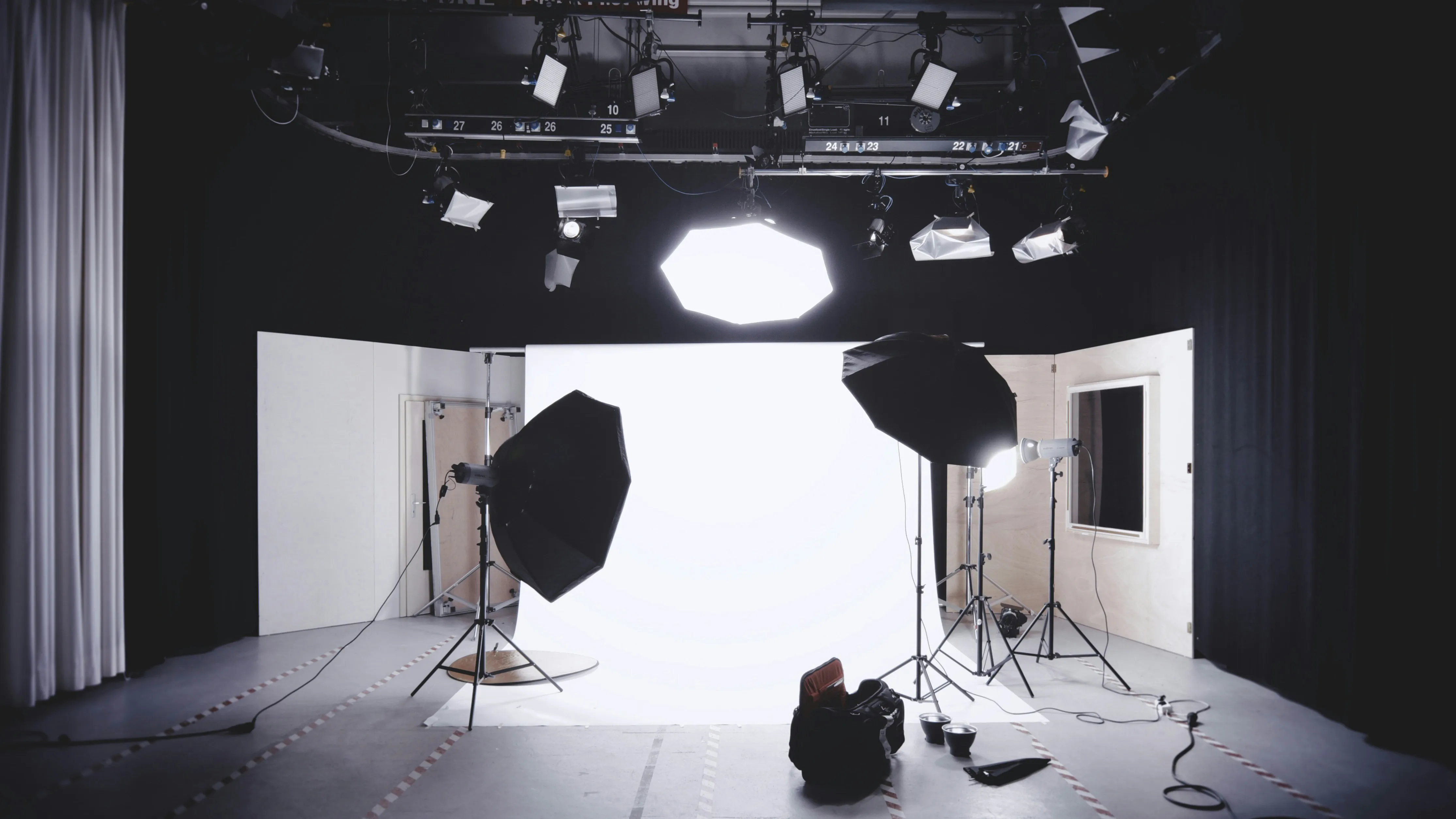 Un studio de tournage installé avec son fond blanc, ses boîtes à lumière et ses projecteurs prêts à servir