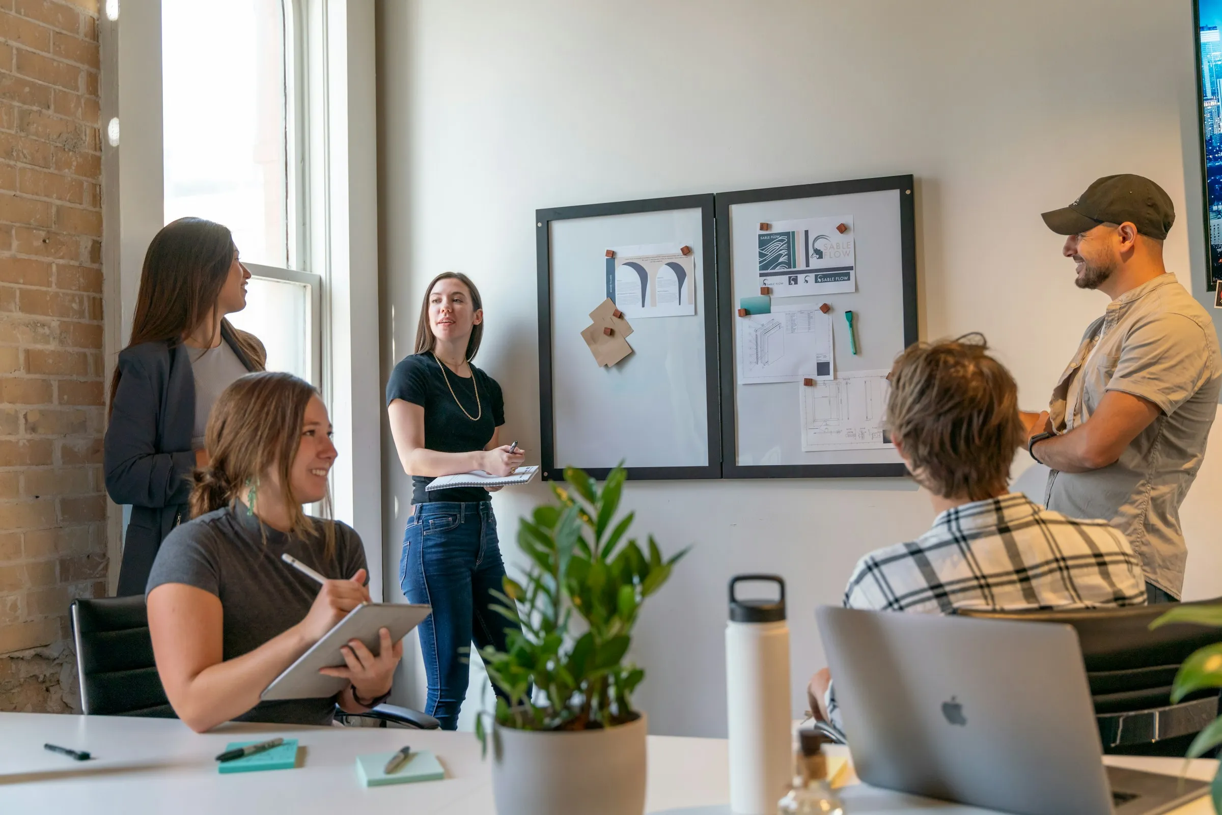 Une équipe réunie autour d'un tableau de campagnes et de parcours de conversion, en train d'arbitrer un dispositif de génération de leads