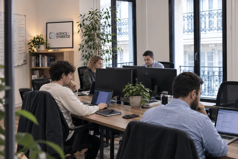 Quatre membres de l'équipe d'Agence Symbiose au travail dans les bureaux de l'agence