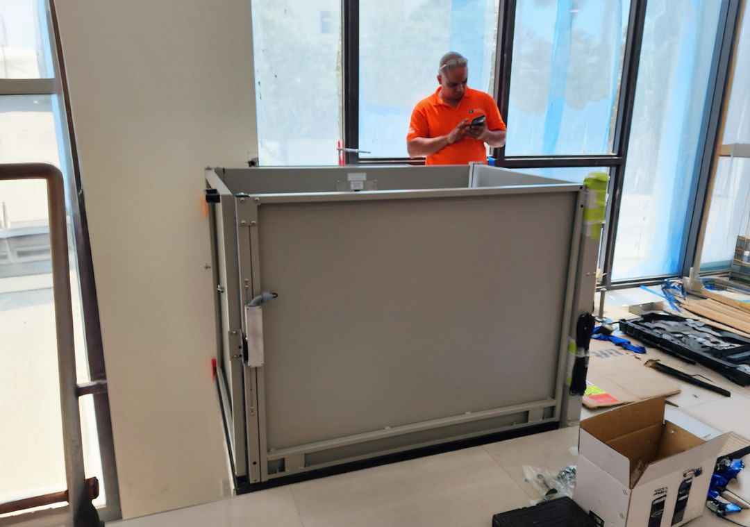 Brouss technician beside a new ADA platform lift during installation