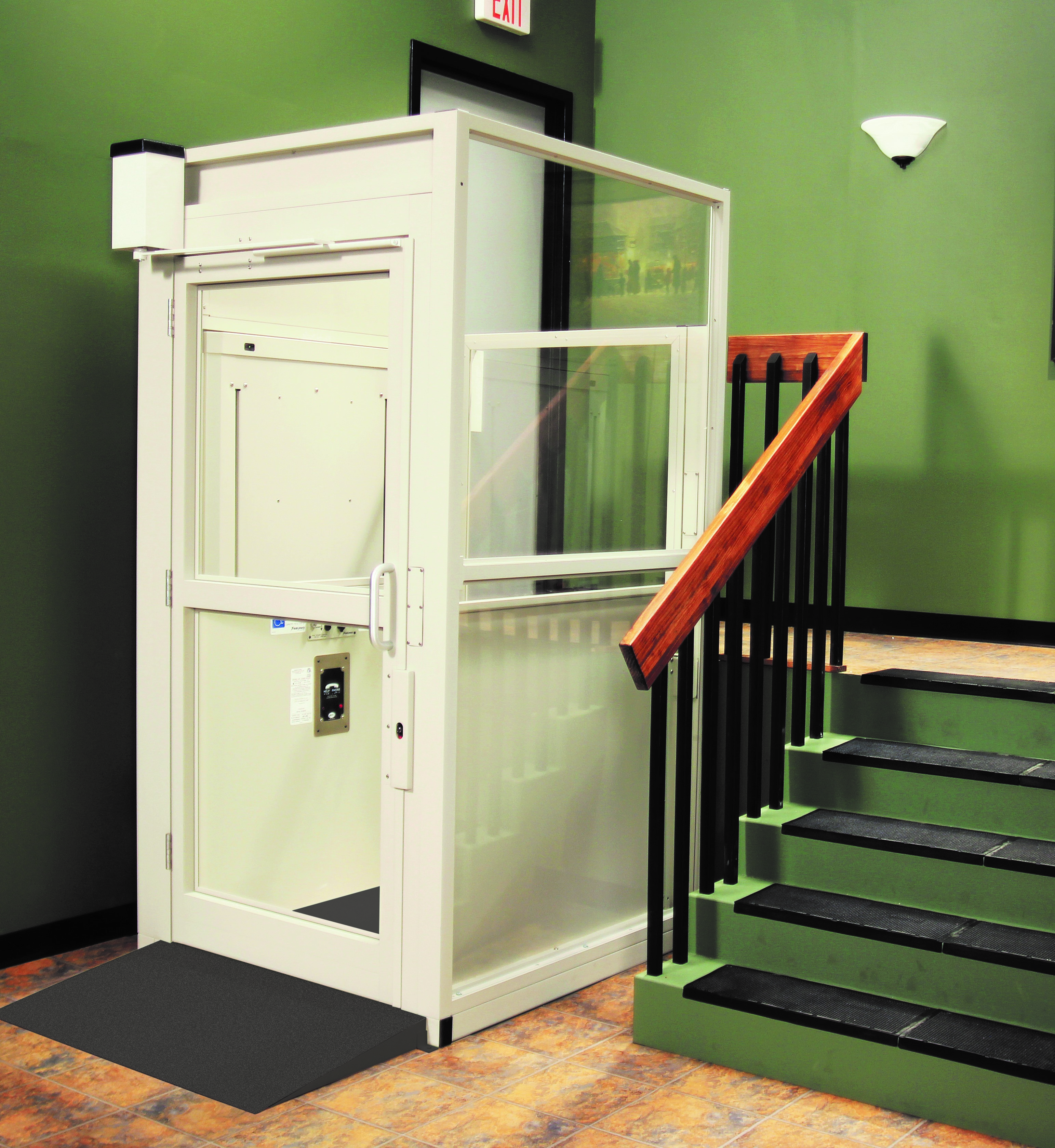 ADA vertical platform lift installed next to stairs in a commercial building