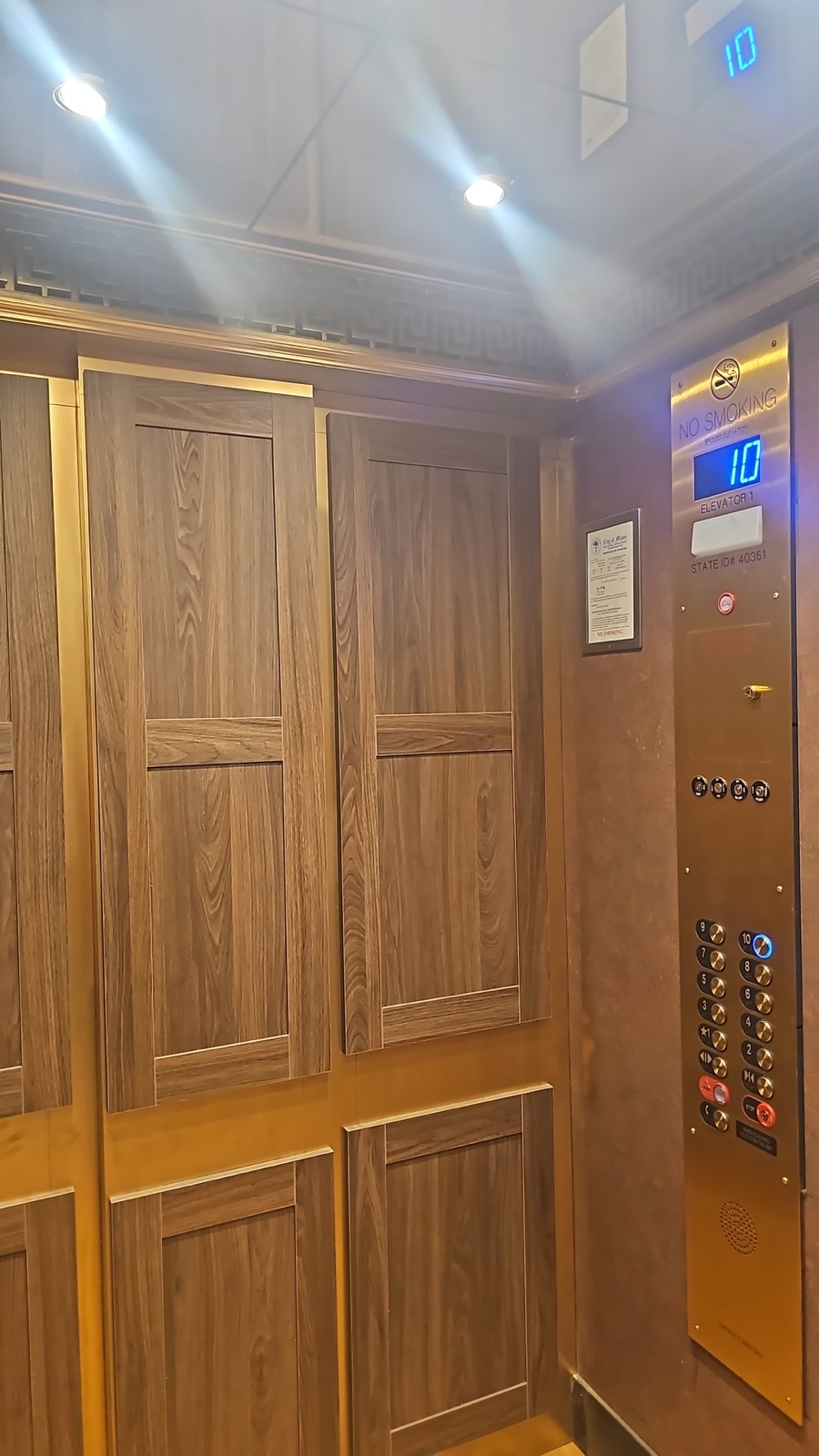 Upgraded elevator cab interior with wood paneling and brushed finish fixtures at Olympia Center