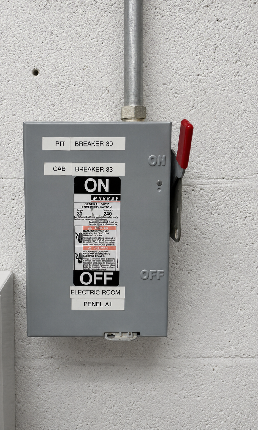 Elevator electrical disconnect switch labeled for pit and cab breakers in the electric room at Mannigan Holdings