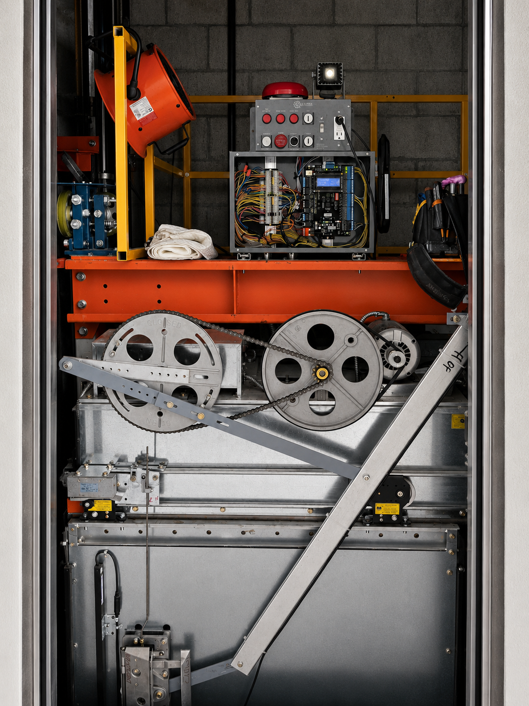 Elevator car top with control panel, alarm bell, sheaves and hydraulic equipment in the hoistway at Univida Medical Center