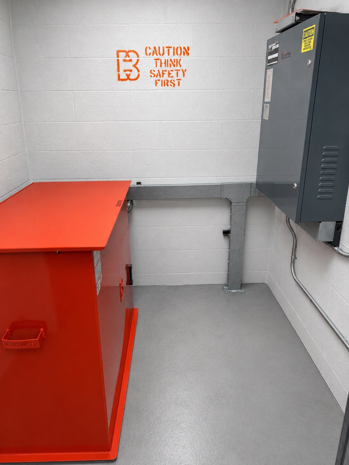 Machine room with the hydraulic power unit and new controller, marked with the Brouss safety stencil, at Sunset Office