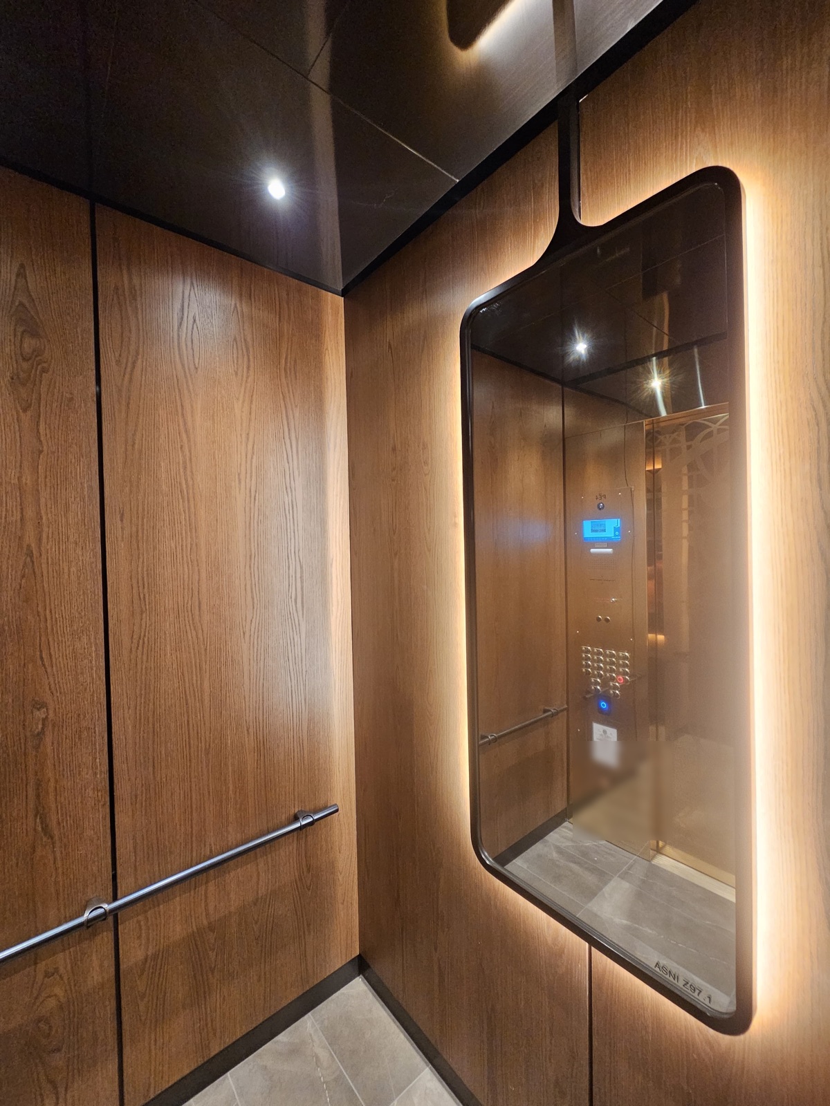 Elevator cab interior with wood panels, a backlit mirror and the new car operating panel at 121 Alhambra