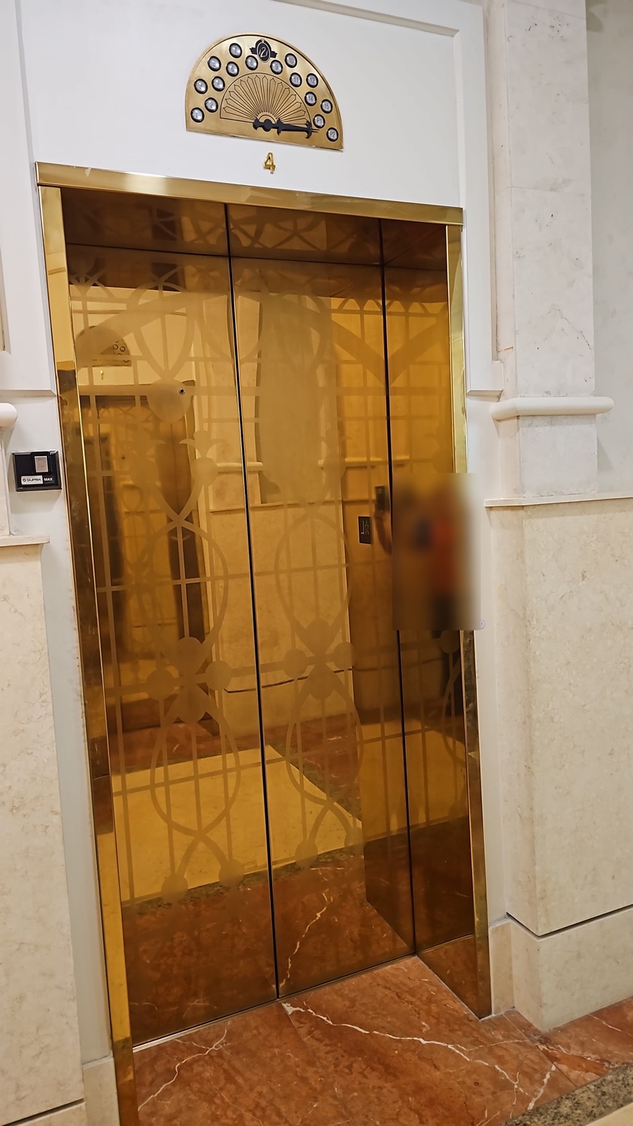 Restored gold Art Deco elevator doors with the floor position indicator at 121 Alhambra