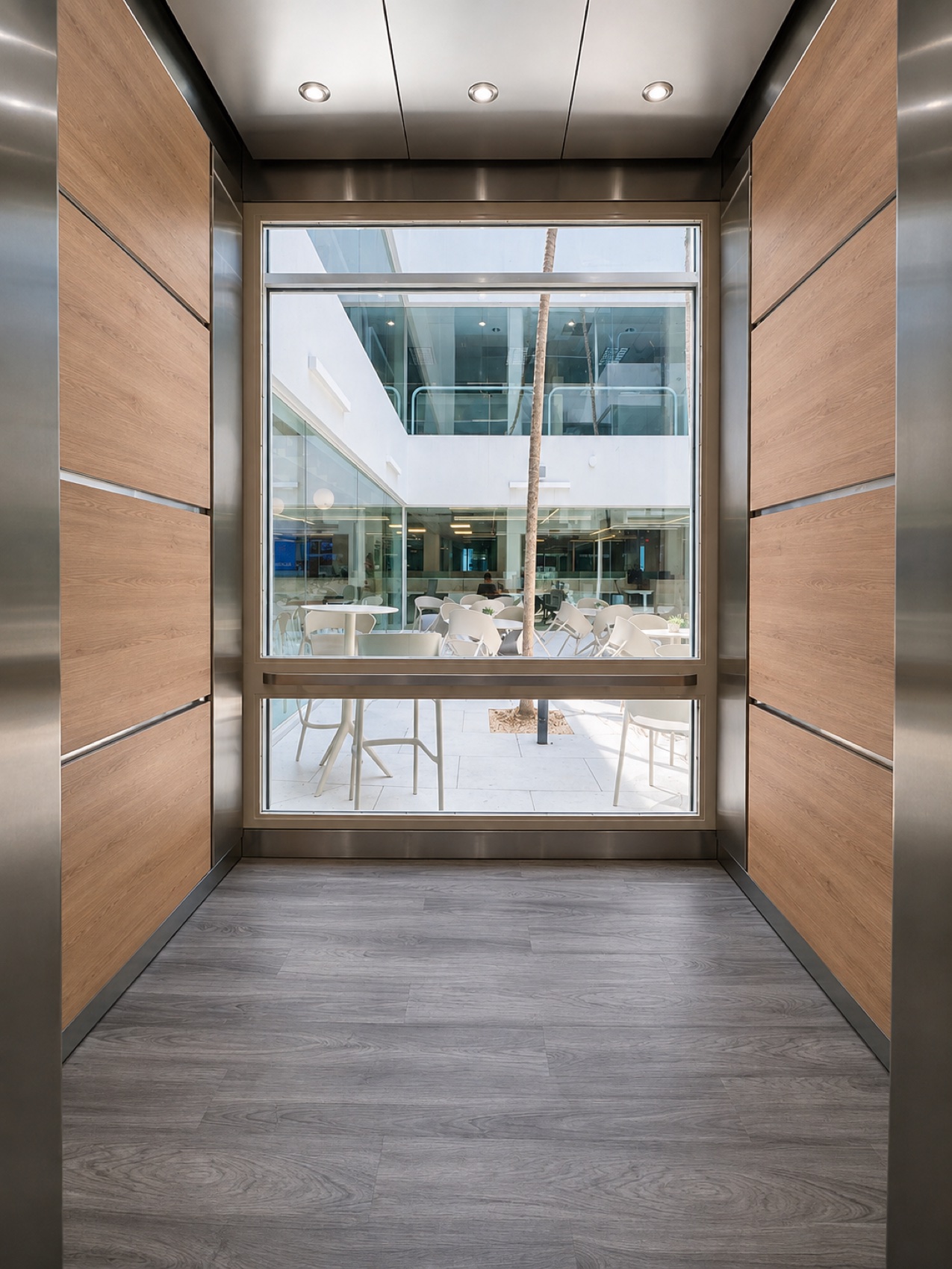 Elevator cab with panoramic glass window overlooking the office courtyard at Ward Law Office Building