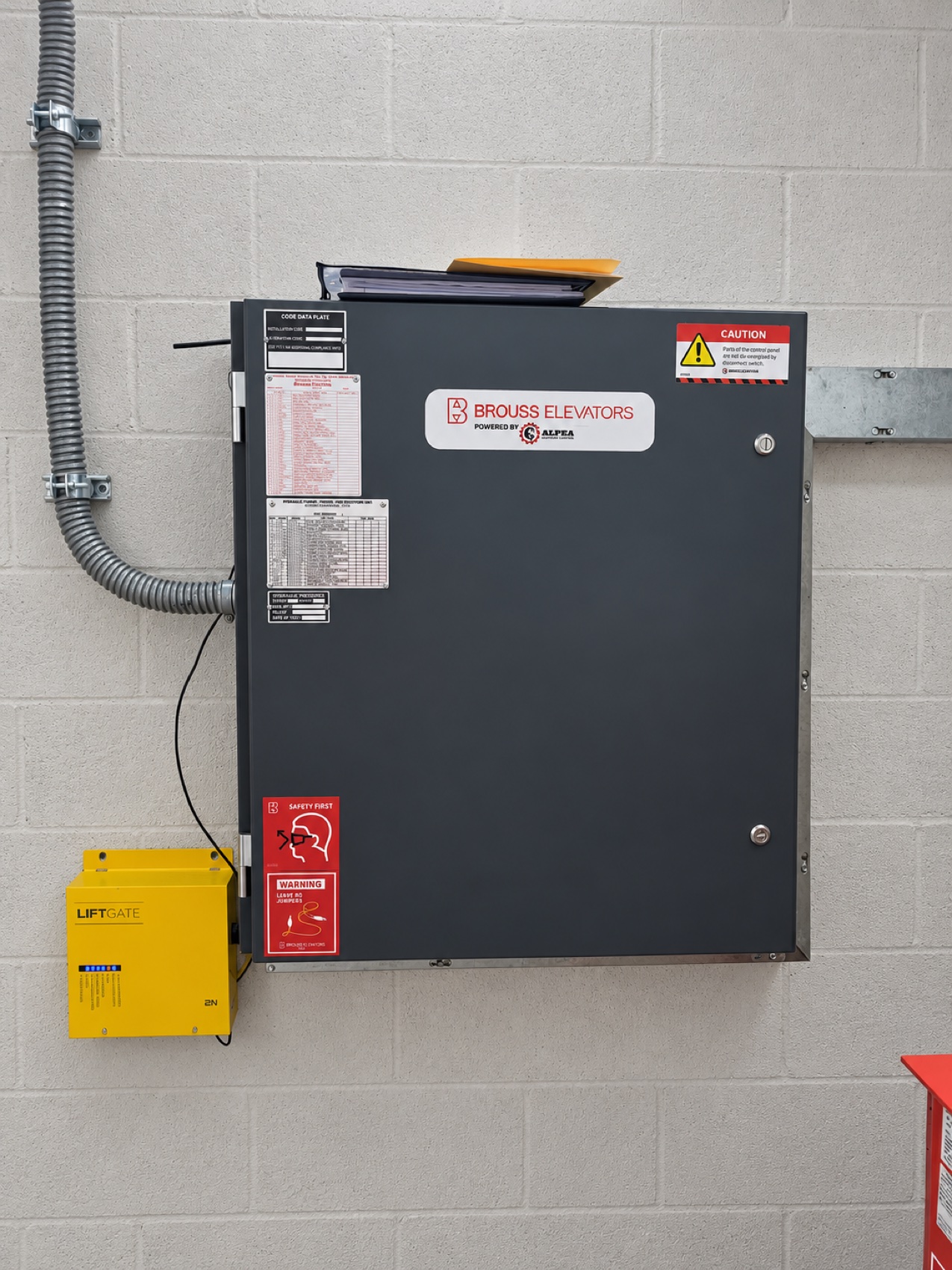 New Brouss Elevators control cabinet installed in the machine room, with the emergency phone unit alongside