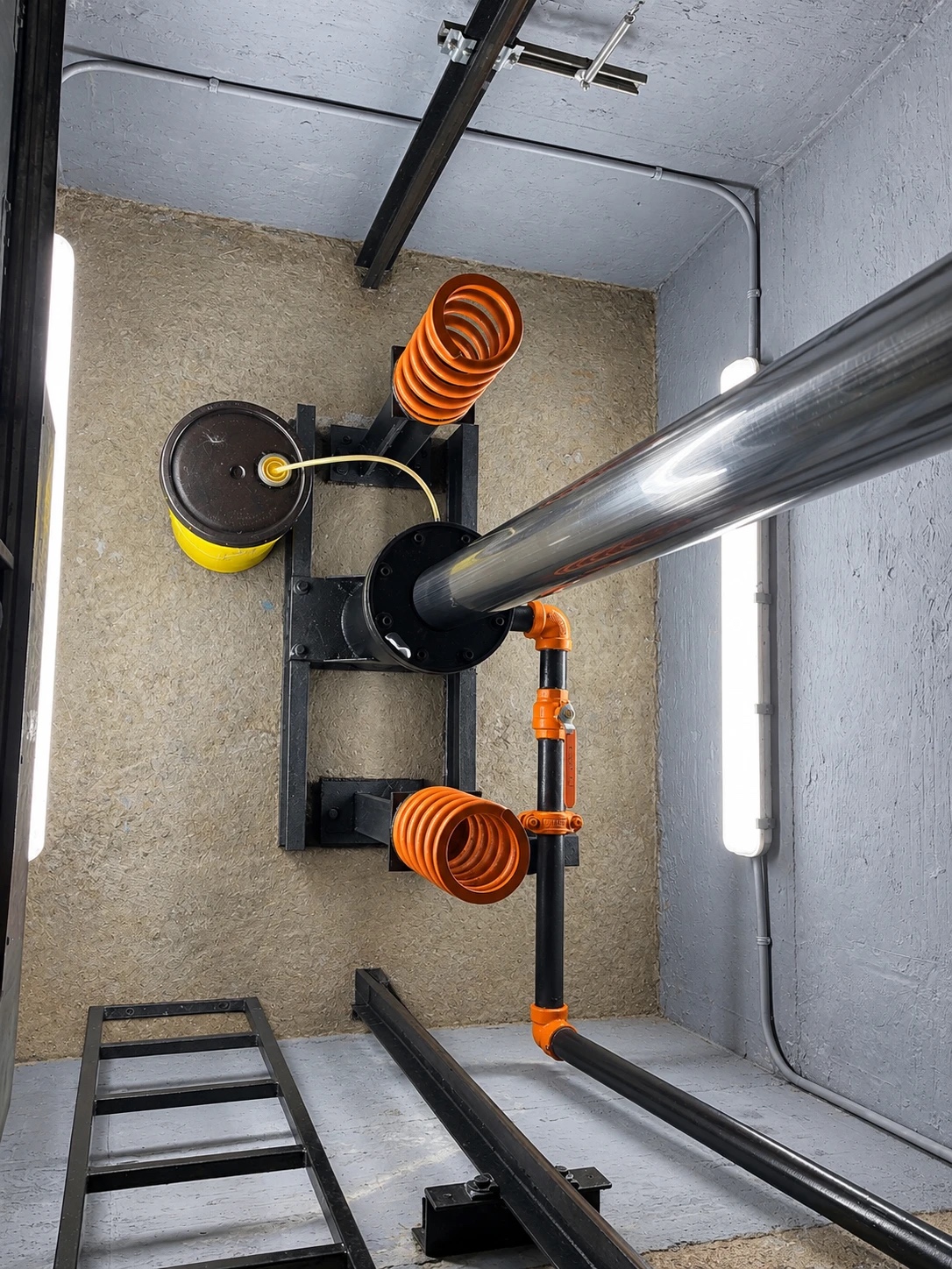 Clean elevator pit at El Prado Condominium with the piston and orange spring buffers