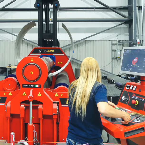 Worker watching steel rolling machinery