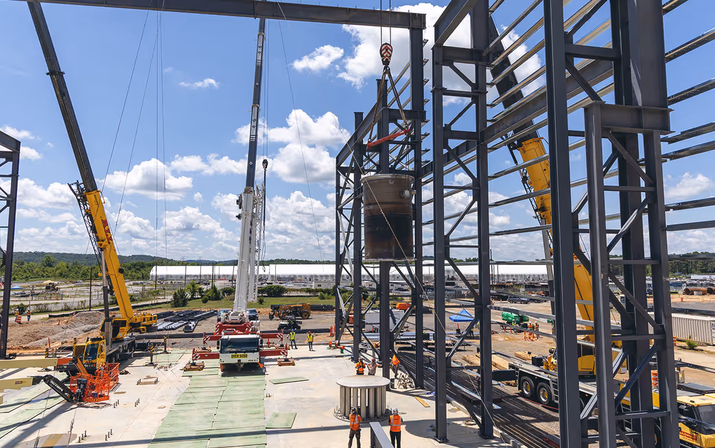 Cranes adding large steel bean to superstructure
