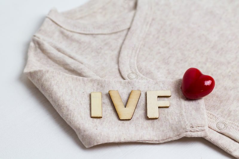 Baby clothes labeled with IVF and a heart.