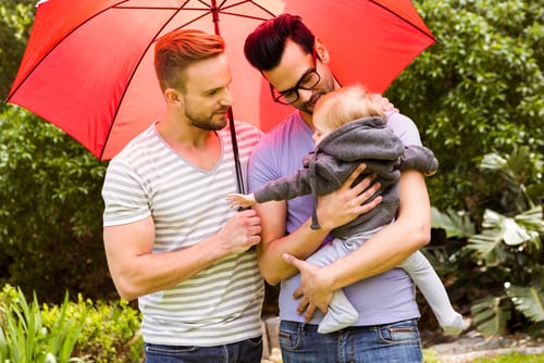 smiling gay couple with child in garden-img-blog