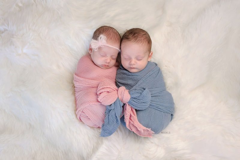 Baby boy and girl swaddled in pink and blue.