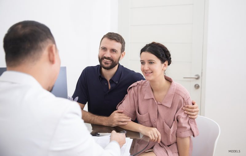 A couple consulting with a doctor in an office