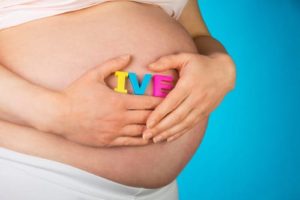 Pregnant woman holding letters