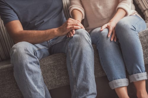 loving couple holding hands while resting on couch at home-img-blog