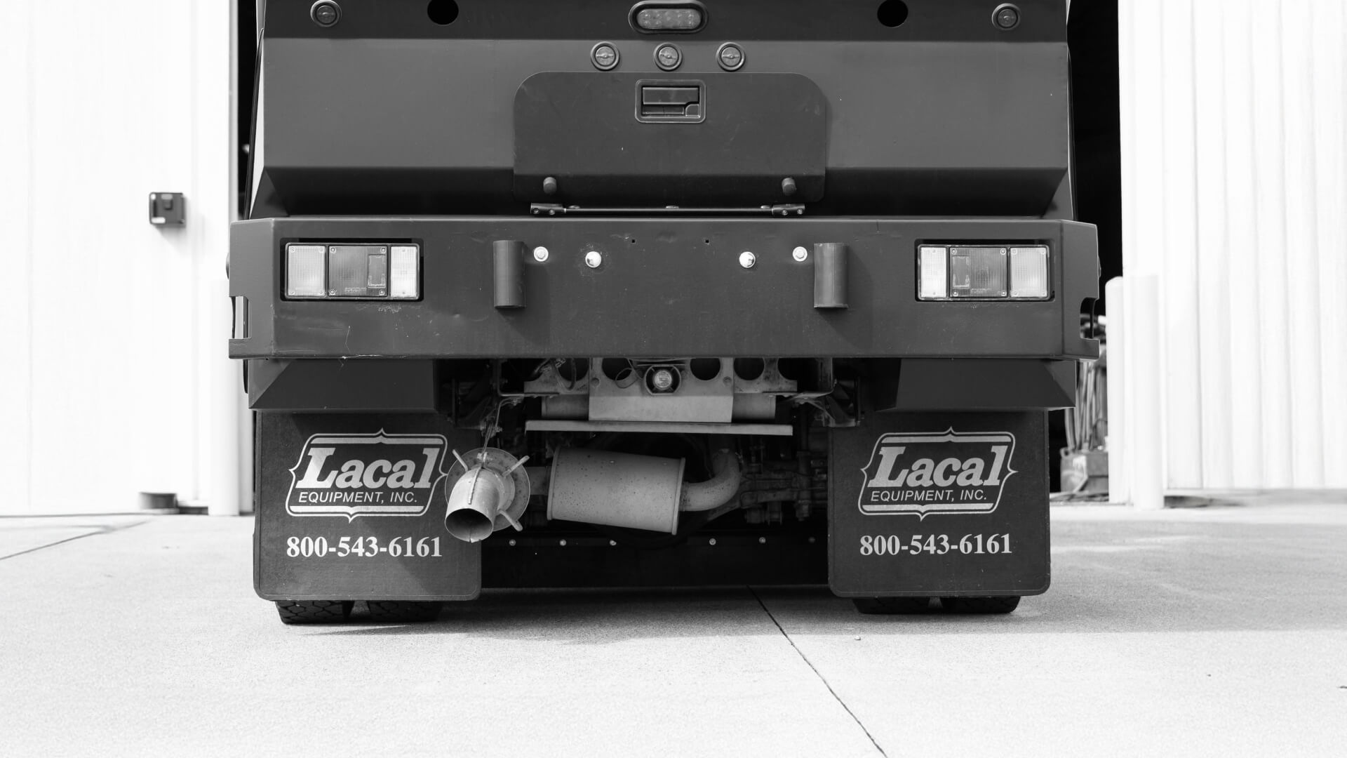Back of a Lacal street sweeper truck.