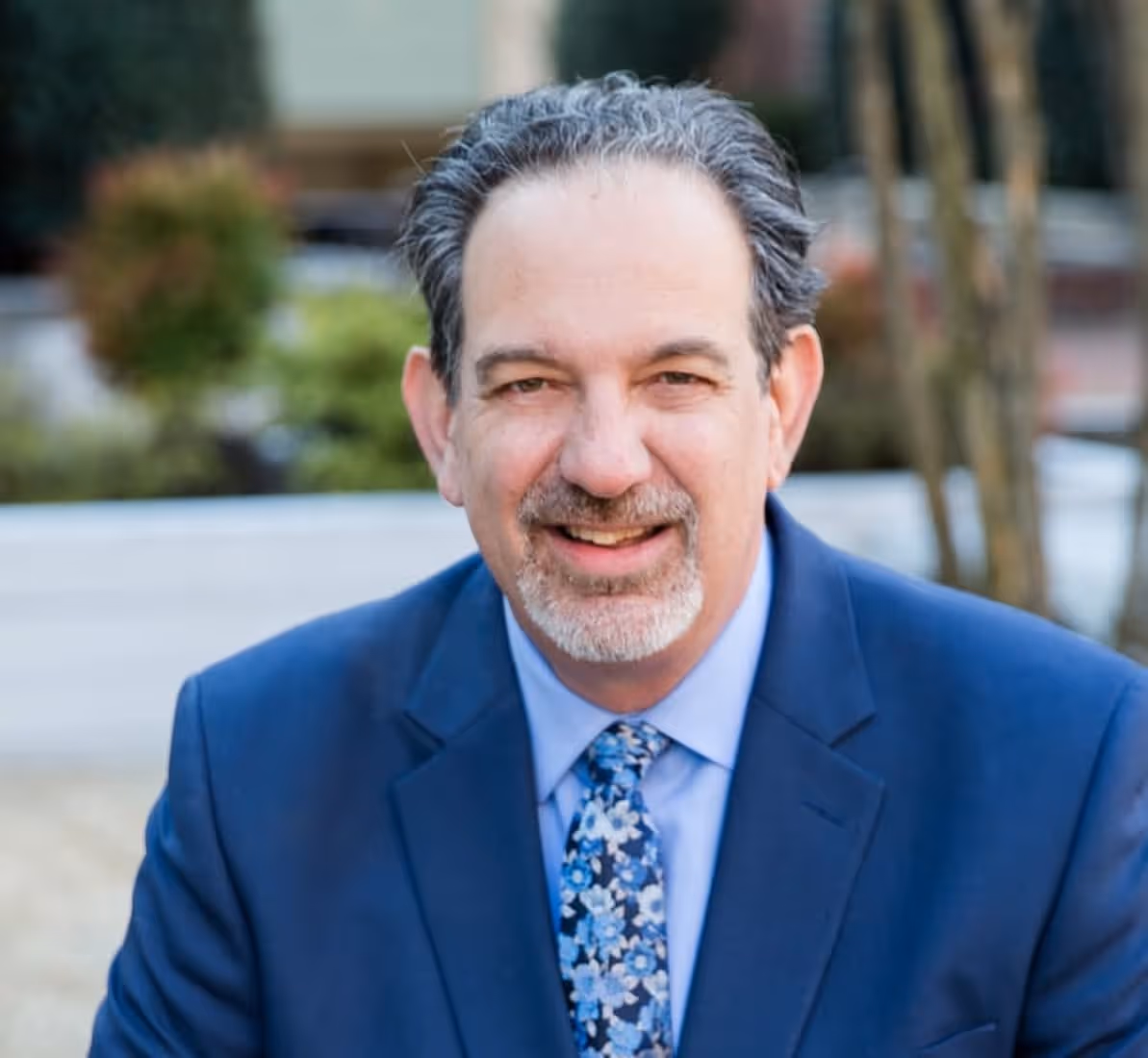 Smiling professional in blue suit representing Affiniti's leadership team