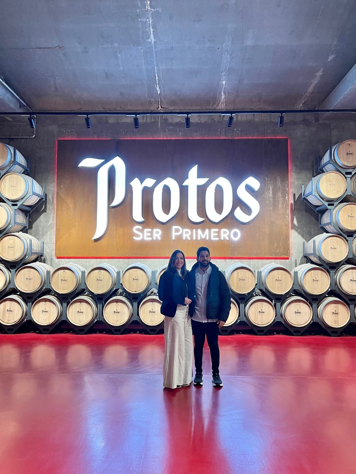 Two travelers in the barrel room at Protos winery.
