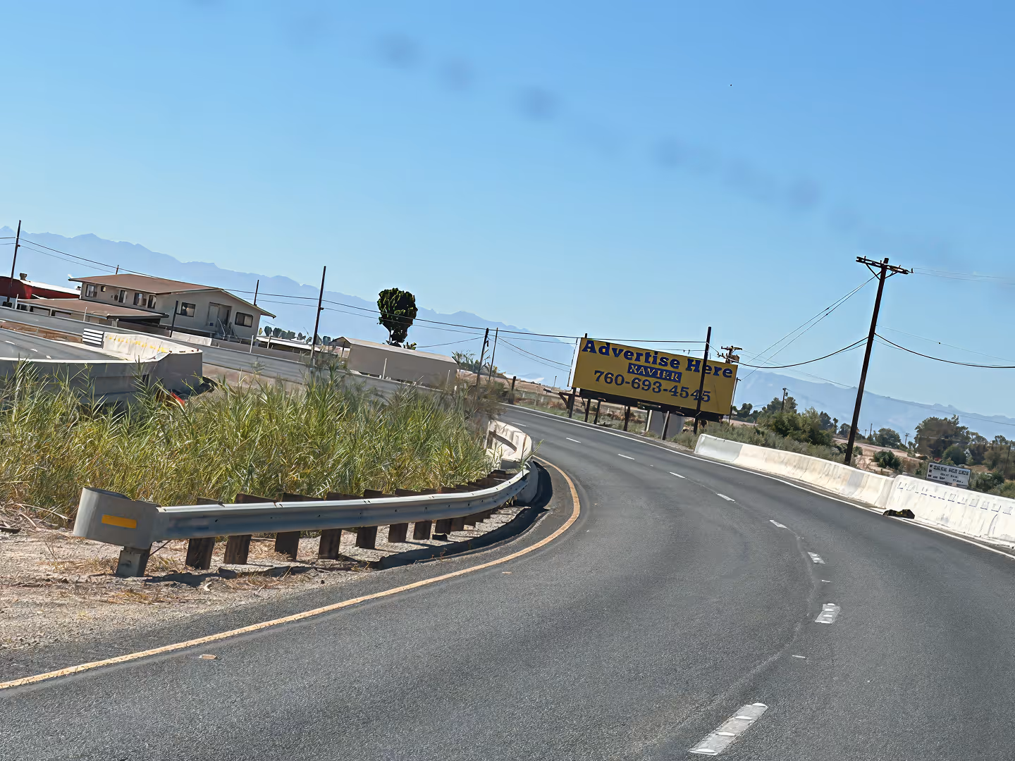 A highway with a blue sky and a sign that says Adventure Haven.