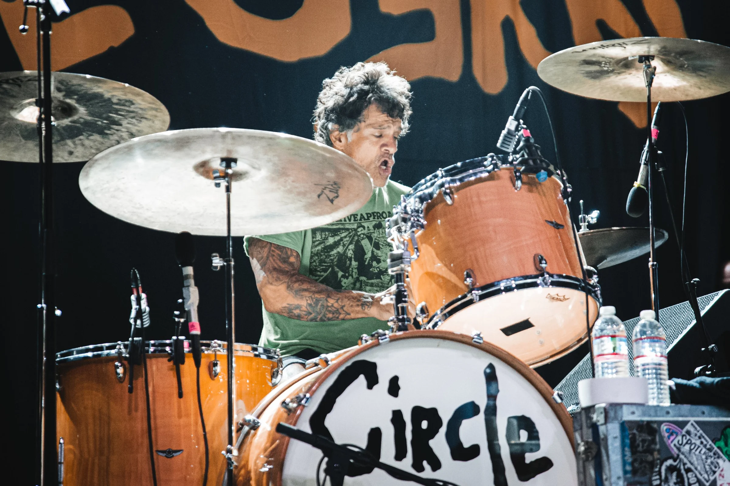 A drummer framed by a ring of stage lights