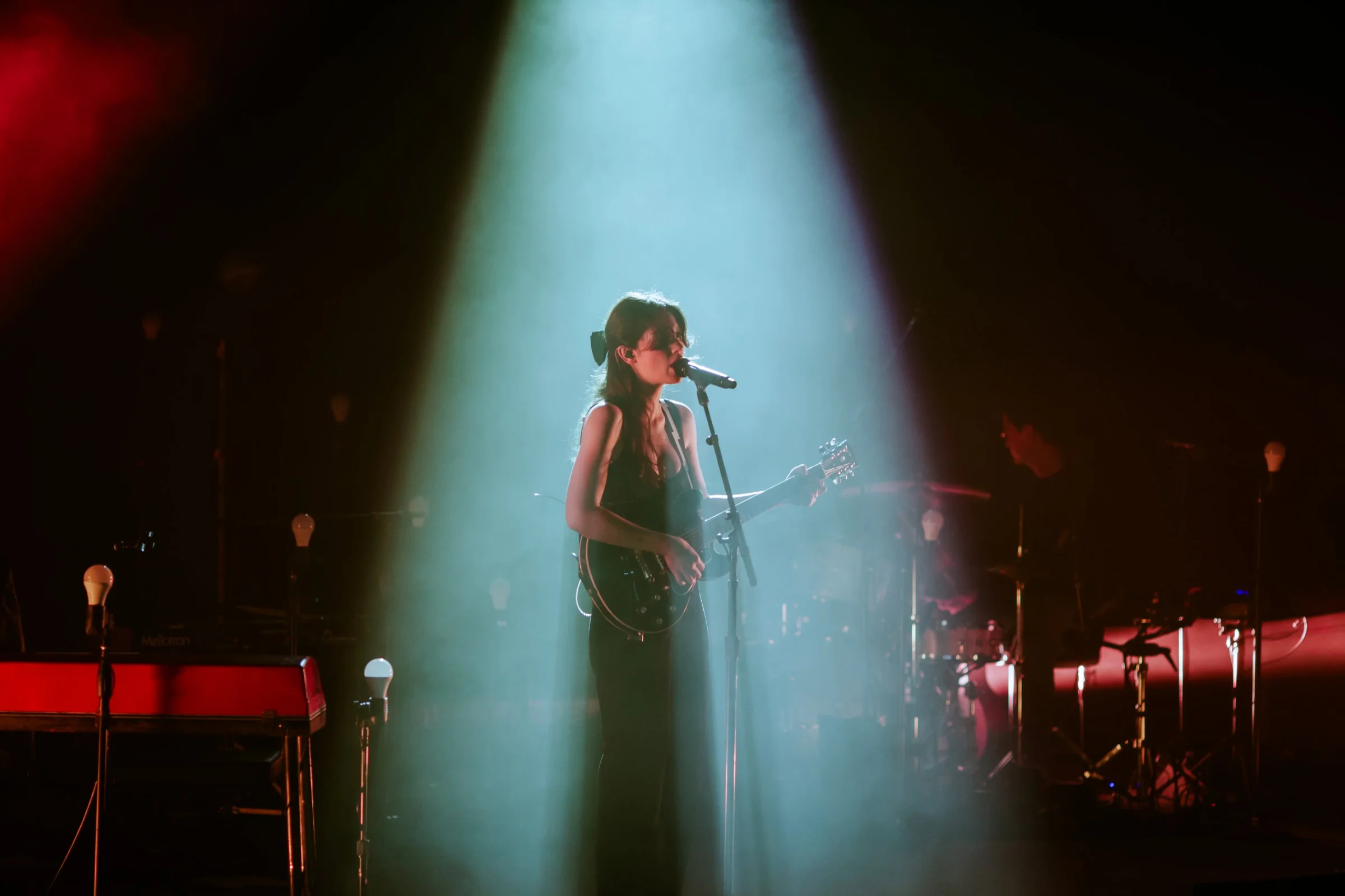 A singer in a teal spotlight
