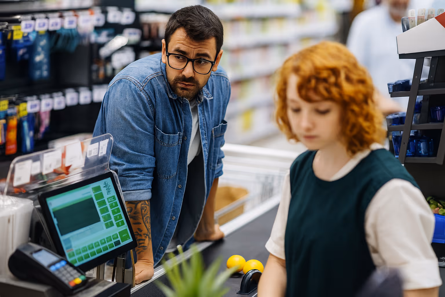 Impatient customer leaning on checkout counter while cashier scans items, symbolizing frustration with poor customer service and disconnected experiences.