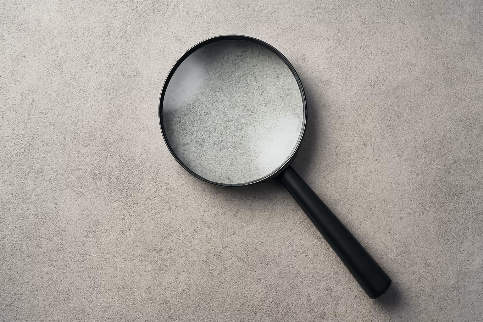 Magnifying glass on concrete background symbolizing search and uncovering insights – Calder & Lane approach