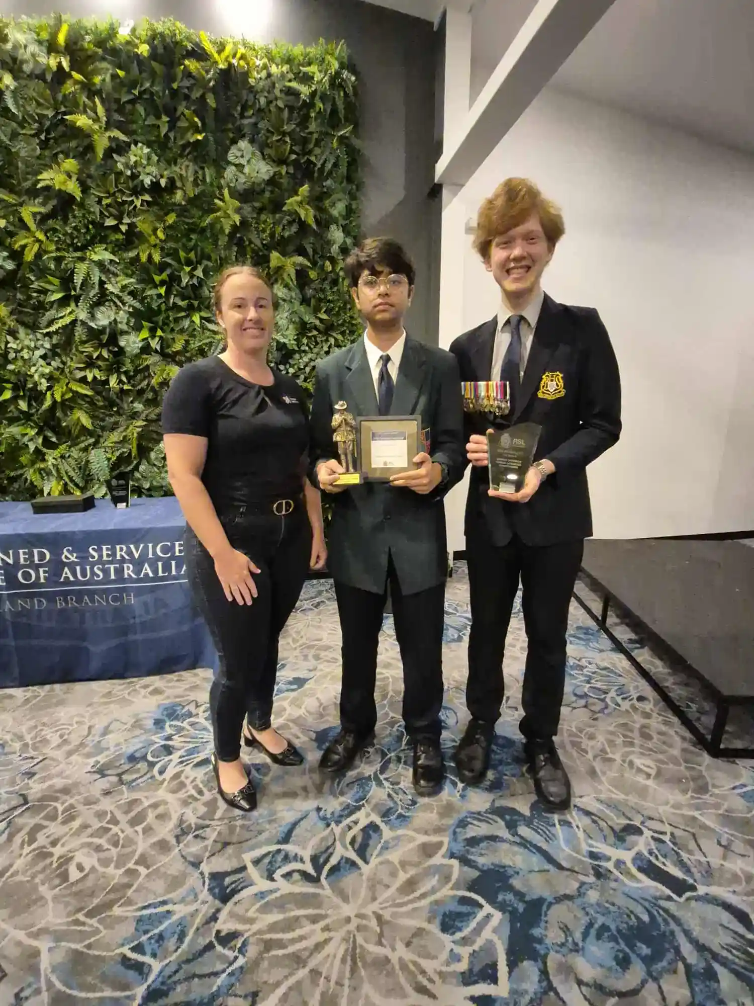 Rachael, Director from Strategic Business Co, presenting trophies to school students in the function room at Bundaberg RSL