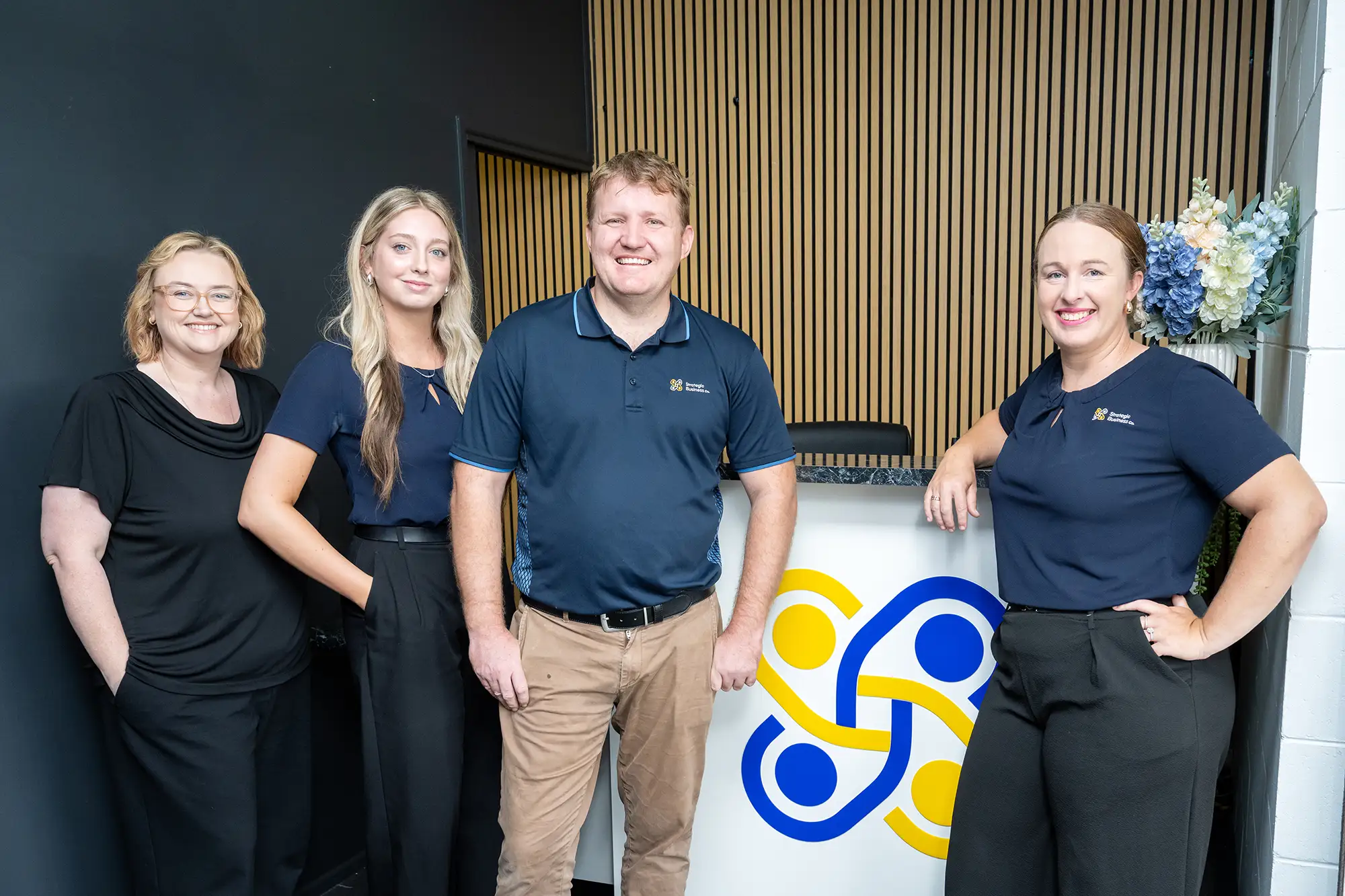 Group photo of the Strategic Business Co team in front of the Reception desk