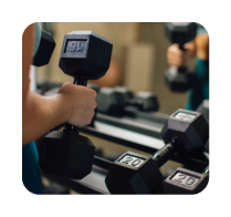 Person lifting a dumbbell from a rack with multiple weights in front of a mirror