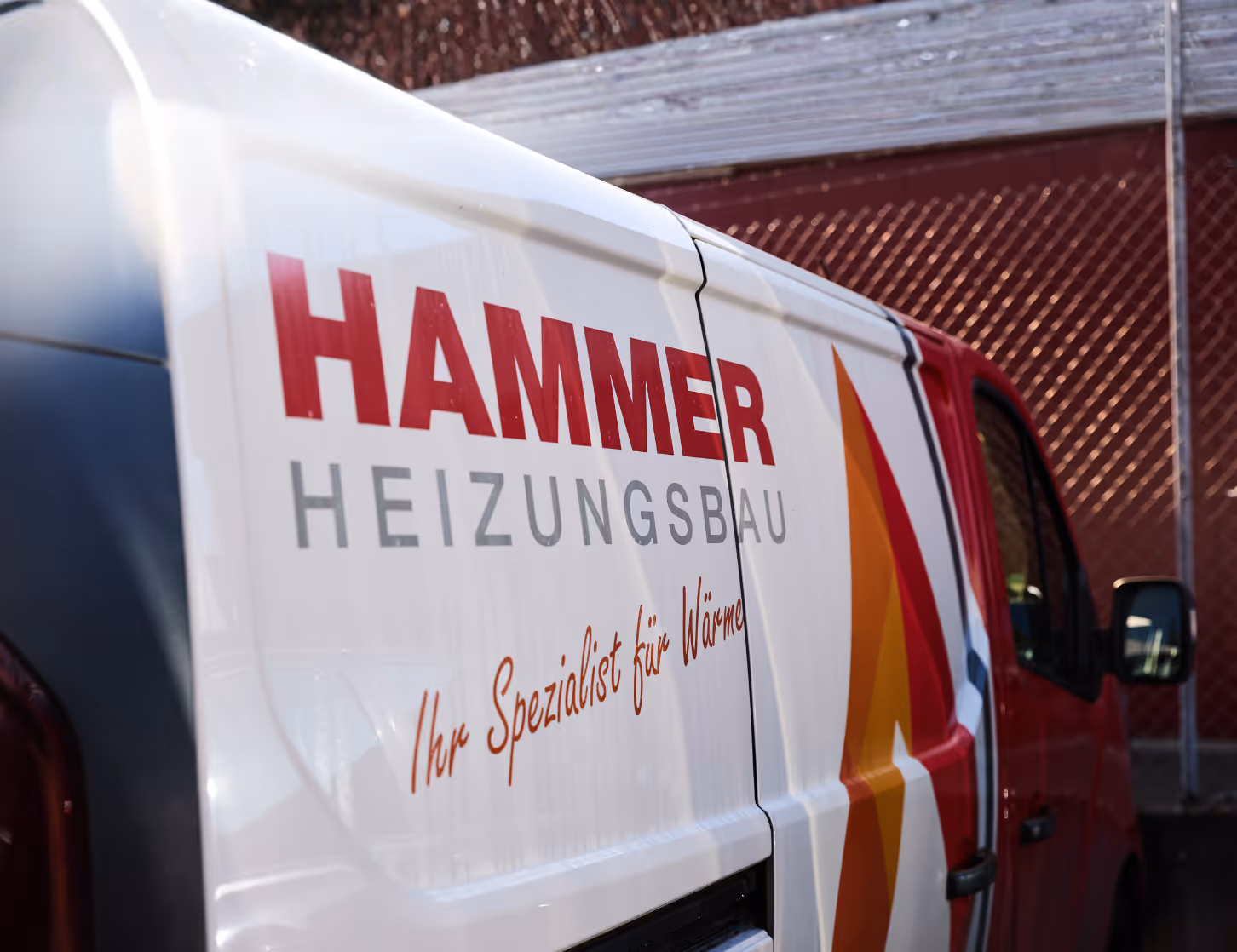 Seitliche Nahaufnahme von Hammer Firmenwagen mit Fahrzeugfolierung