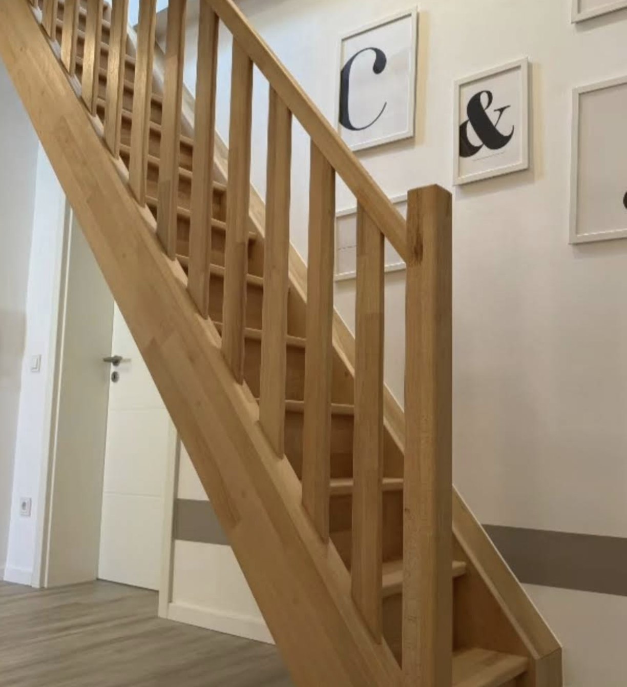Klassische Eichenholz-Treppe mit Stabgeländer im modernen Hausflur. Individueller Treppenbau der Schreinerei Holzbären.