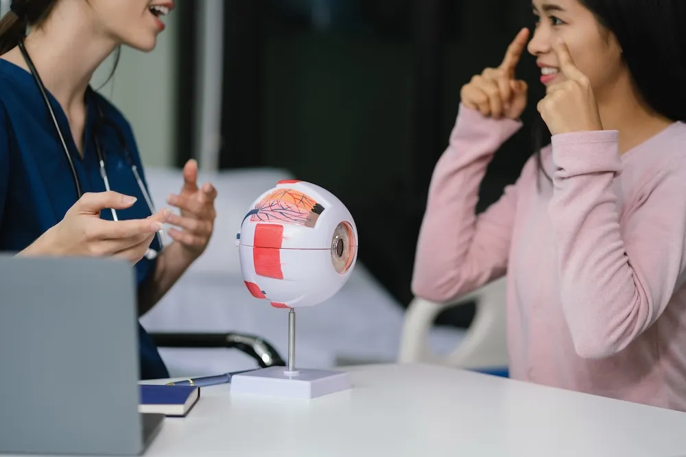 Doctor explaining eye anatomy using detailed anatomical model to patient