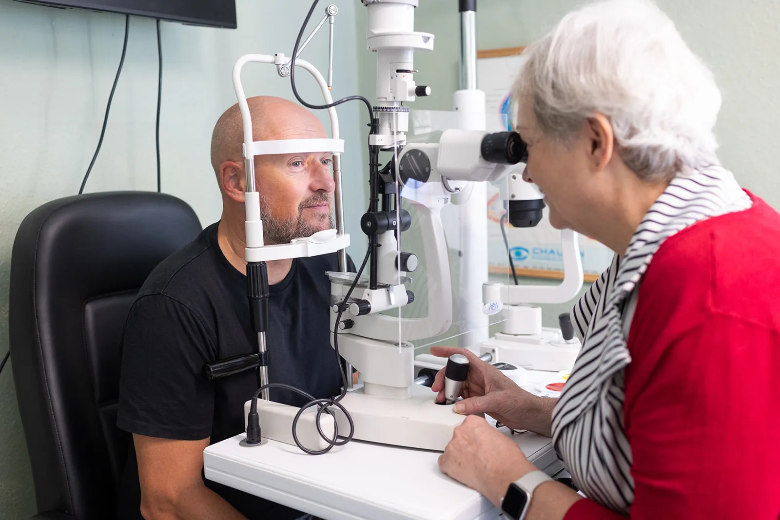 Patient receiving eye examination using professional optical diagnostic equipment