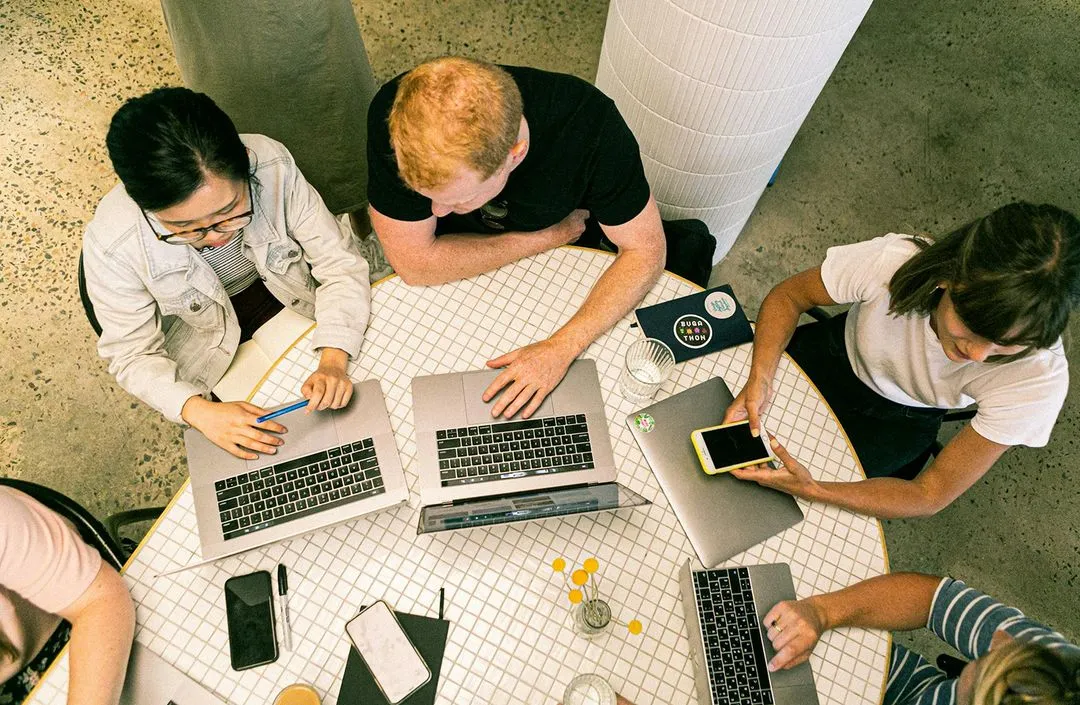 People working on laptops in a round table