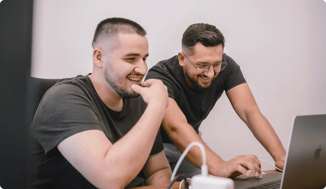 2 guys looking at a laptop