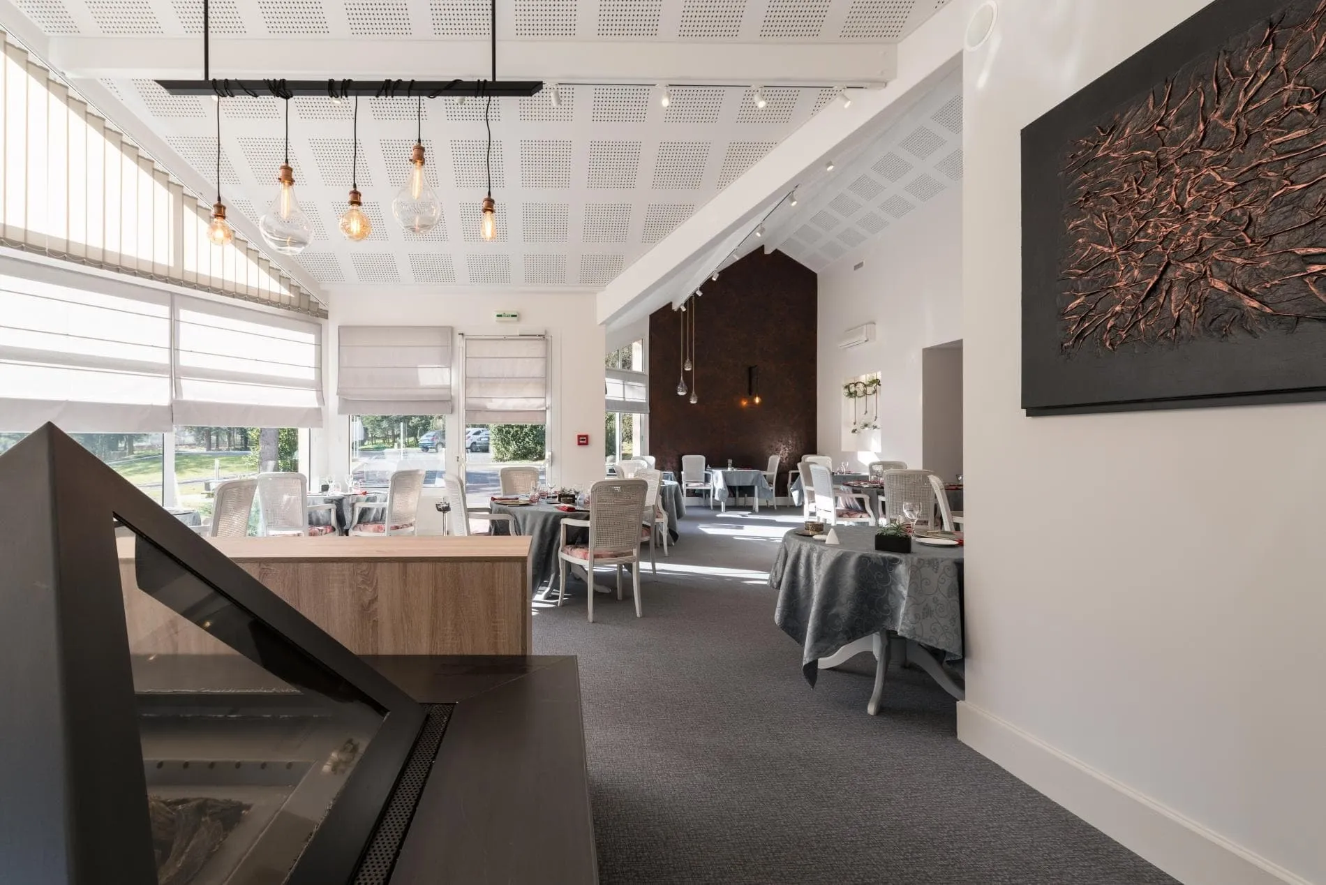 Salle de restaurant lumineuse avec véranda ouverte sur le parc, aux Cèdres Bleus à Aurec-sur-Loire