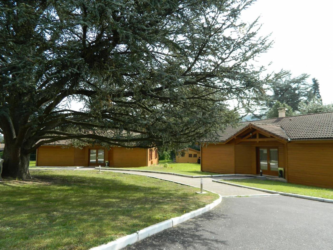 Pavillons en bois nichés sous les cèdres centenaires du parc des Cèdres Bleus à Aurec-sur-Loire