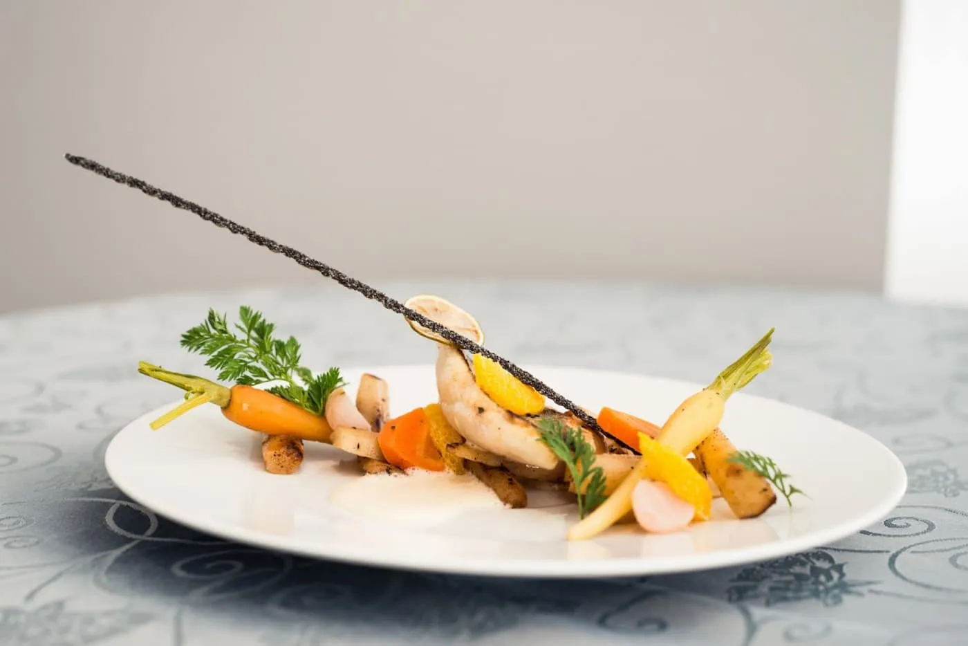 Assiette gastronomique élégante de légumes et volaille, dressée avec finesse