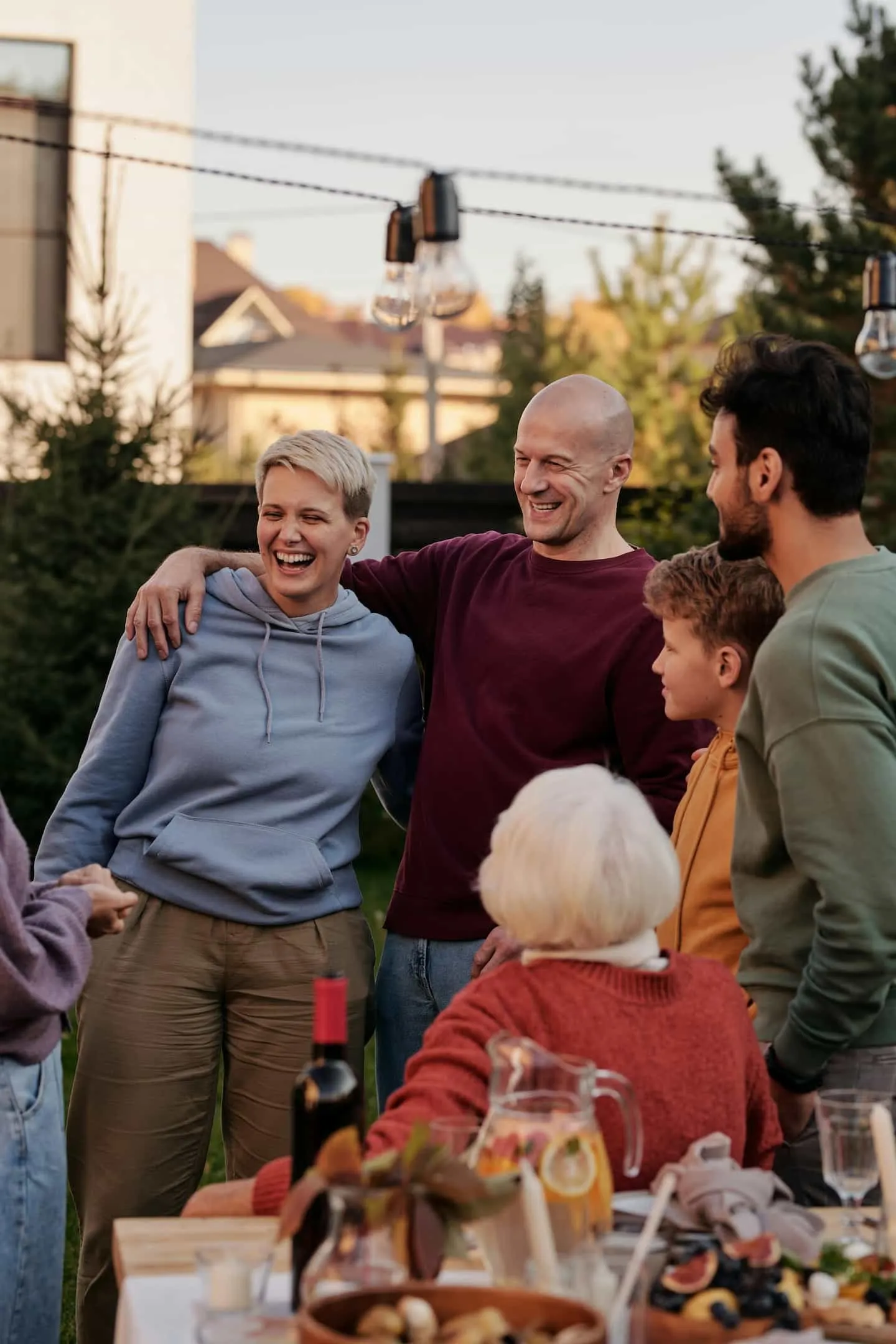 Famille multigénérationnelle réunie en extérieur pour un moment convivial autour d’un repas