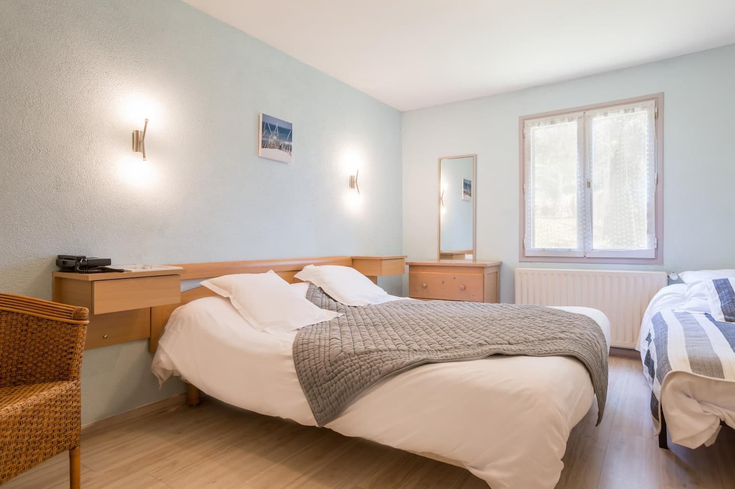 : Chambre familiale lumineuse avec lit double, lit simple, parquet clair et mobilier en bois naturel